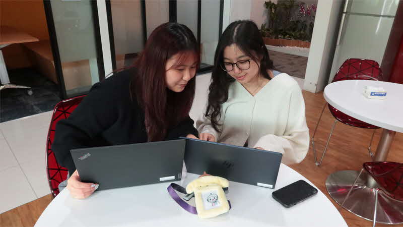 Hui Xin bouncing ideas off a colleague during a work session.